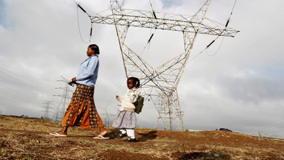 A woman walks her child to school past high voltage electrical pylons on the outskirts of Kenya's capital Nairobi,