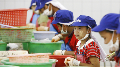 Tae (C), a 13-year-old girl from military-ruled Myanmar, peels shrimp at a factory in Samut Sakhon, nearly 40 km (25 miles) south of Bangkok April 20, 2007. The Labour Rights Promotion Network (LPN), a non-governmental organisation, estimates there are 200,000 Myanmar migrant workers in Samut Sakhon -- of whom only 70,000 are registered legally. To match feature THAILAND-CHILDLABOUR/ REUTERS/Adrees Latif