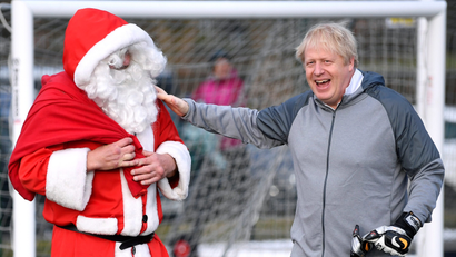 Britain's Prime Minister Boris Johnson greets a man dressed as Santa Claus in 2019.