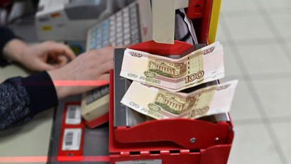 Russian 100-rouble banknotes are placed on a cashier's desk at a supermarket in the Siberian town of Tara in the Omsk region, Russia.