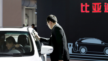 A staff member cleans a BYD electric car during the Auto China 2016 in Beijing, China, April 25, 2016.