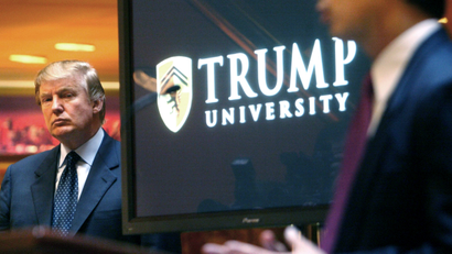 In this May 23, 2005 file photo, real estate mogul and Reality TV star Donald Trump, left, listens as Michael Sexton introduces him at a news conference in New York where he announced the establishment of Trump University. New York Attorney General Eric Schneiderman is suing Trump for $40 million, saying that “Trump University” didn’t deliver on its advertised promise to make students rich, but instead steered them into expensive yet mostly useless seminars.
