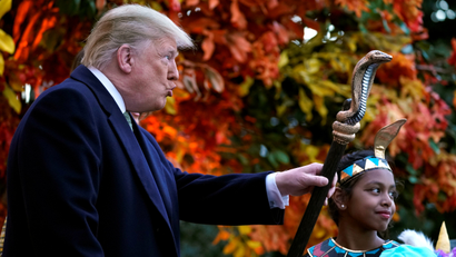 U.S. President Donald Trump waves the staff of a child dressed as a pharaoh as he hands out Halloween candy to trick-or-treaters at the White House in Washington, U.S., October 28, 2018.