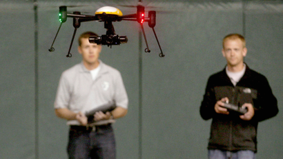 FILE - In this June 24, 2014 file photo, Jake Stoltz, left, and Trevor Woods of the John D. Odegard School of Aerospace Sciences at the University of North Dakota in Grand Forks, remotely pilot a Draganflyer X4ES drone during a demonstration at the Alerus Center in Grand Forks, N.D. Organizers of an annual unmanned aircraft conference are calling North Dakota the Silicon Valley of the drone world. Some of the top aerospace experts in the country are meeting Wednesday, Sept. 23, 2015, in Grand Forks to talk about research and business opportunities in the state. (AP Photo/Bruce Crummy, File)