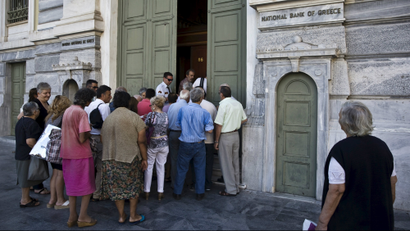 People wait to enter a National Bank branch in Athens.