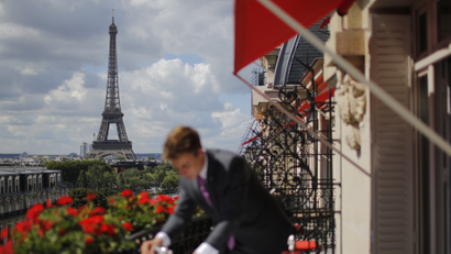 An employee prepares breakfast in front of the Eiffel tower at the Parisian luxury hotel Le Plaza Athenee, France July 30, 2015.
