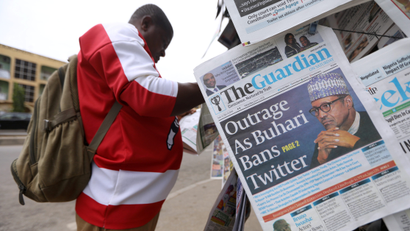 Man reads a newspaper at a newsstand in Abuja