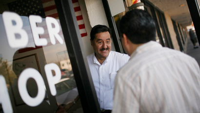 Xavier Rivas, a Republican activist working on Sen. John McCain's Nevada Leadership Team, visits a barbershop in Henderson, Nev., Friday, Sept. 26, 2008. The man who once risked his career on an immigration reform bill that was embraced by Hispanics is now struggling to win these same voters, and falling perilously below the level of support that helped lift President Bush to the White House. The candidate who won nearly 70 percent of Hispanic voters in his last bid for Senate in border-state Arizona is watching a first-term Illinois senator run away with those voters. (AP Photo/Jae C. Hong)