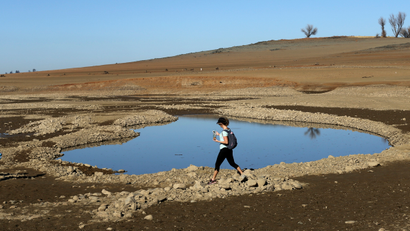 A visitor walks near the receding waters at Folsom Lake, which is 17 percent of its capacity, in Folsom, California January 22, 2014. California Governor Jerry Brown last week declared a drought emergency, and the dry year of 2013 has left fresh water reservoirs with a fraction of their normal water reserves. Picture taken January 22, 2014. REUTERS/Robert Galbraith (UNITED STATES - Tags: ENVIRONMENT TPX IMAGES OF THE DAY) - RTX17T4L