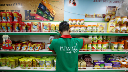 A worker arranges consumable goods inside a Patanjali store in Ahmedabad