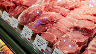Selection of red meat on display in supermarket.