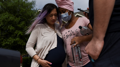 A doula holds a pregnant woman