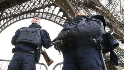 Police take up position under the Eiffel Tower the morning after a series of deadly attacks in Paris