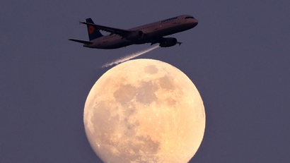 An airplane of German air carrier Lufthansa passes the moon over Frankfurt, Germany, April 9, 2017.
