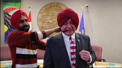 Dan Curtis, the mayor of the Canadian city Whitehorse, in the process of putting on a Sikh turban.