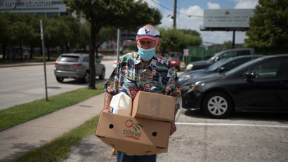 A man carries groceries from a food bank.