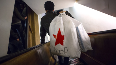 Shoppers ride the escalator at Macy's Herald Square in New York in this November 28, 2013