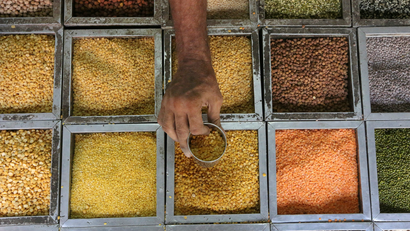 An employee collects lentils from a container.