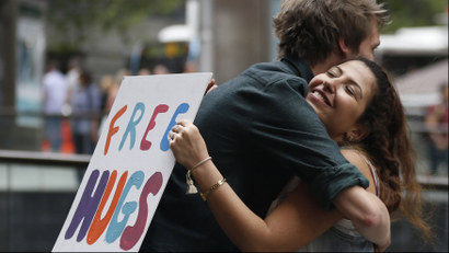 woman holding free hugs sign