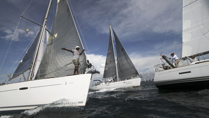Three sailboats close to one another during a regatta