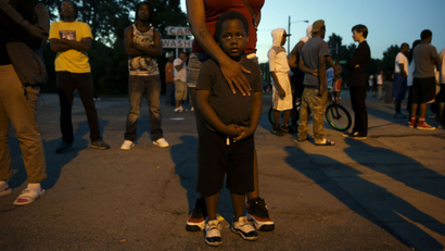 A black boy stands in Ferguson