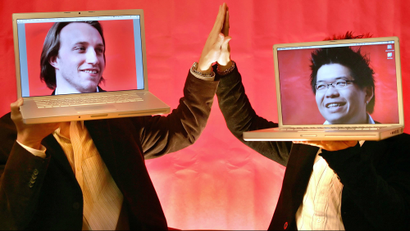 YouTube co-founders Chad Hurley and Steven Chen pose with their laptops