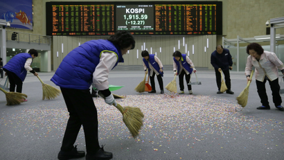 Workers sweep confetti with the brooms after the year's market market closing ceremony at the Korea Exchange in Seoul, South Korea, Tuesday, Dec. 30, 2014. The Korea Composite Stock Price Index closed the year's last trading at 1,915.59. (AP Photo/Ahn Young-joon)