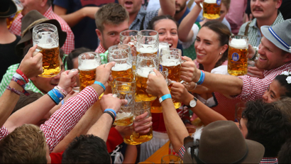 Visitors cheer with beers during the opening day of the 185th Oktoberfest in Munich