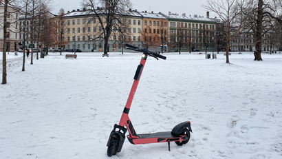 A Voi scooter parked in snowy Oslo.