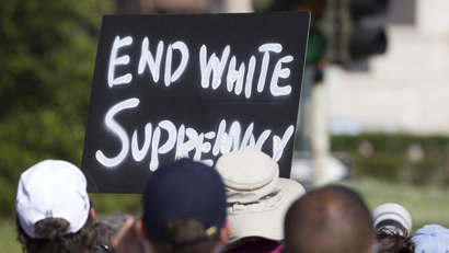 protestor holding "end white supremacy" sign