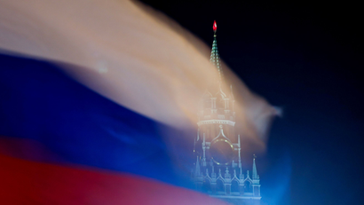 A Russian flag flies with the Spasskaya tower of Moscow's Kremlin in the background