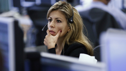 A worker on IG Index's trading floor looks at her computer screens.