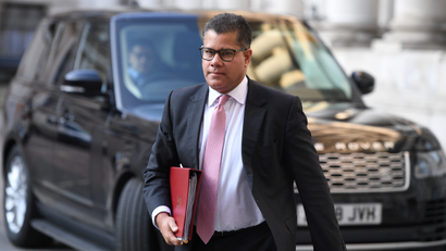 Britain's Business Secretary Alok Sharma walks with a red file.