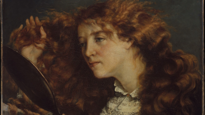 A red-haired woman brushes her hair while looking in the mirror in a painting by Gustave Courbet