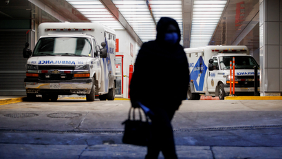 A person walks away from two ambulances parked at a hospital