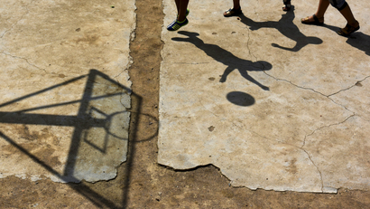 Students cast shadows as they play basketball at a playground at Dalu primary school in Gucheng township of Hefei, Anhui province, China