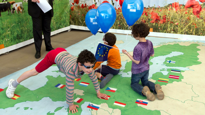 Children play a game to find countries that are in the EU on a giant map outside of EU headquarters in Brussels on Saturday, May 4, 2013. Once a year EU institutions open their doors and provide a local fair in which EU countries can display their local culture to the general public.