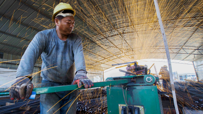 A worker cuts steel bars at a railway bridge construction site in Lianyungang, Jiangsu province.