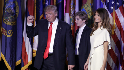 President-elect Donald Trump pumps his fist after giving his acceptance speech as his wife Melania Trump, right, and their son Barron Trump follow him during his election night rally, Wednesday, Nov. 9, 2016, in New York
