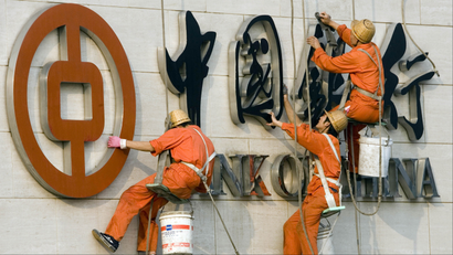 Workers repair a Bank of China sign