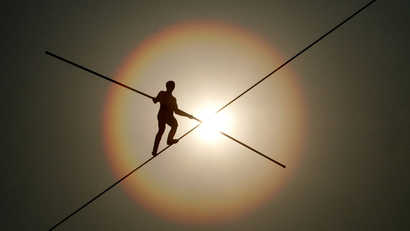 silhouette of a person balancing on a tight rope
