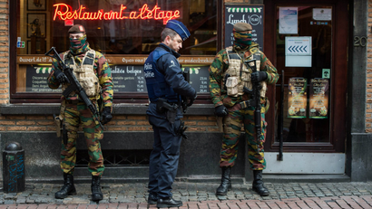 A Police officer and soldiers stand guard in the 'Rue des Bouchers' street, famous for it's restaurants, following the terror alert level being elevated to 4/4, in Brussels, Belgium, 22 November 2015.