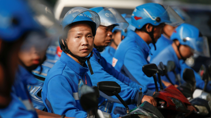Drivers of the food delivery service Ele.me prepare to start their morning shift after an internal security check in Beijing, China, September 21, 2017. Picture taken September 21, 2017.