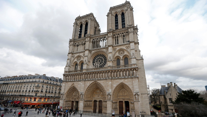 People walk past the entrance to the Notre Dame Cathedral in Paris
