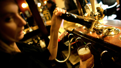 A barmaid pulls a pint at a pub in central London.