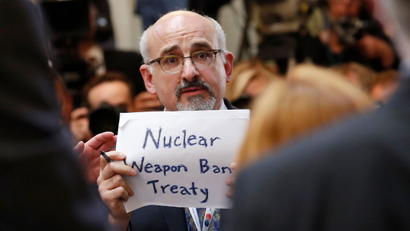 A man holds a sign reading 'Nuclear Weapon Ban Treaty' at Trump and Putin's meeting in Finland in July 2018.