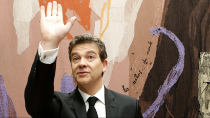 French Economy Minister Arnaud Montebourg waves as he arrives at the National Assembly for a conference on the selling of French engineering company Alstom