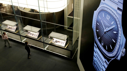 Visitors walk past the exhibition stand of Swiss watch manufacturer Patek Philippe at the Baselworld watch and jewelry fair in Basel, Switzerland March 20, 2019