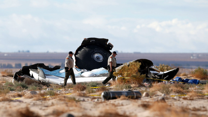 Sheriff's deputies look at a piece of debris near the crash site of Virgin Galactic's SpaceShipTwo near Cantil, California November 1, 2014. Virgin Galactic founder Richard Branson said on Saturday he was working with U.S. authorities to determine what caused a passenger spaceship being developed by his space tourism company to crash in California, killing one pilot and injuring the other.