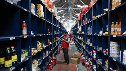An employee scans a package for an order at a Big Basket warehouse on the outskirts of Mumbai November 4, 2014. Put off by snarled city traffic and a shortage of parking, more Indians are shopping for groceries online, helping e-tailers like Bigbasket.com and Localbanya.com turn in profits while supermarkets are struggling. Picture taken November 4. To match INDIA-INTERNET/RETAIL REUTERS/Danish Siddiqui (INDIA - Tags: BUSINESS FOOD)